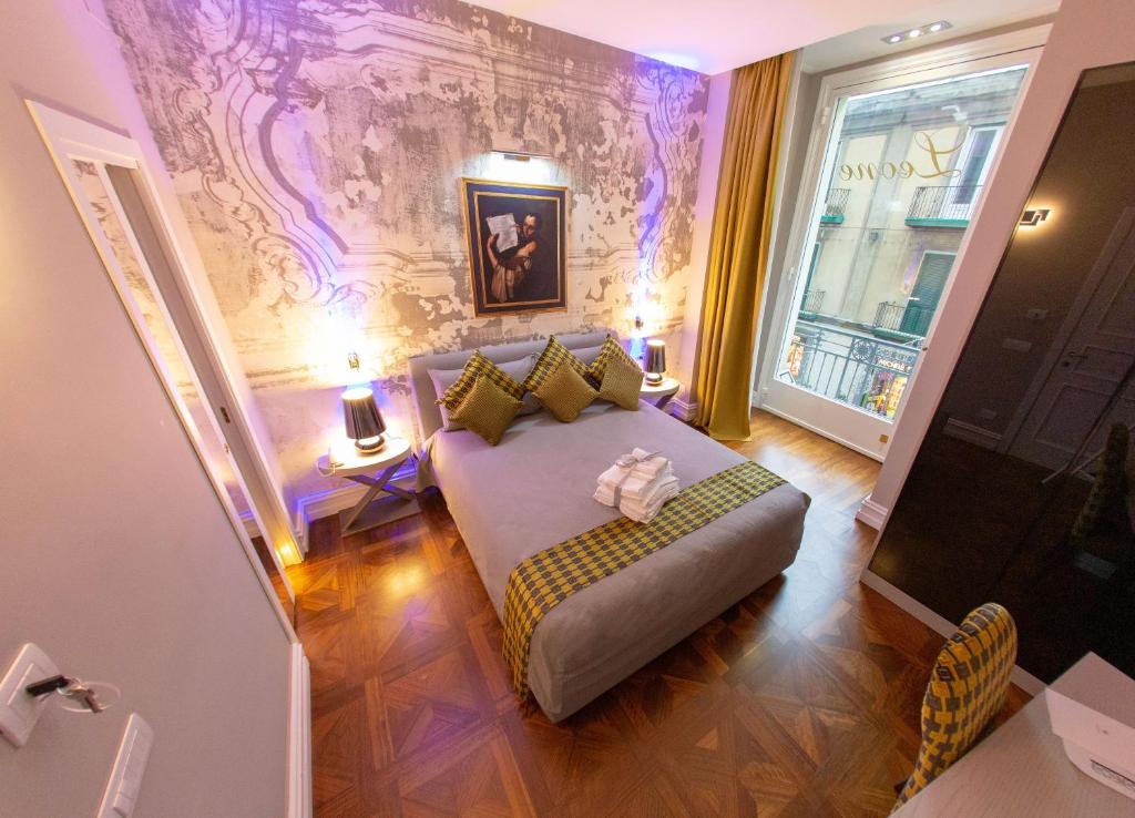 una camera con letto e divano di Leone Camere D'autore - CHIAIA a Napoli