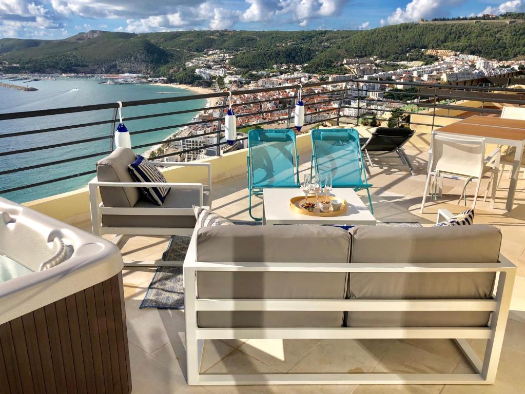 a balcony with chairs and a view of a city at Sky & Sea in Sesimbra