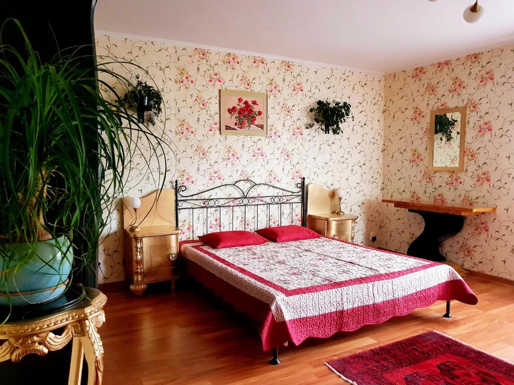 a bedroom with a bed with red pillows on it at Pensjonat Nostalgia in Kołobrzeg
