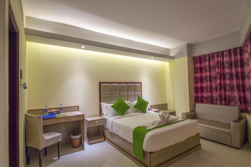a bedroom with a large bed and a large window at Hotel Mira Garden in Sylhet