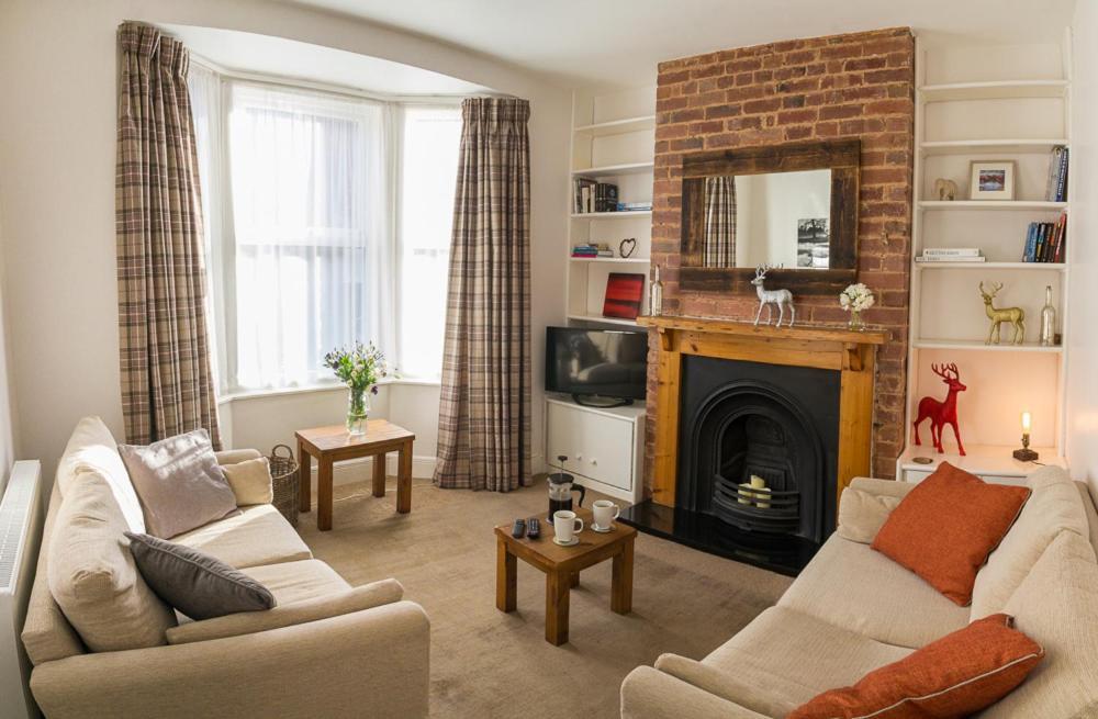 uma sala de estar com um sofá e uma lareira em 15 Saxon Road em Exeter
