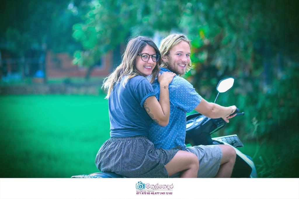 a man and a woman sitting on a motorcycle at Moon Light Guest House in Tissamaharama