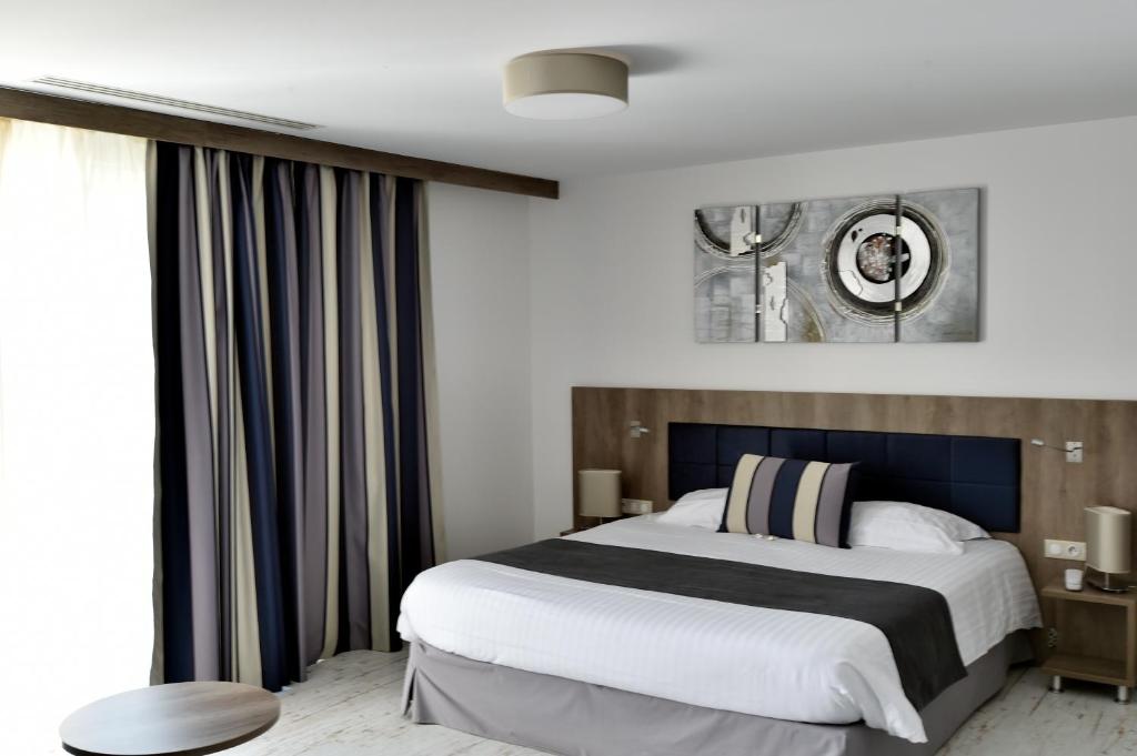 a bedroom with a large bed and a large window at Le Domaine des Oliviers in Pierrelatte