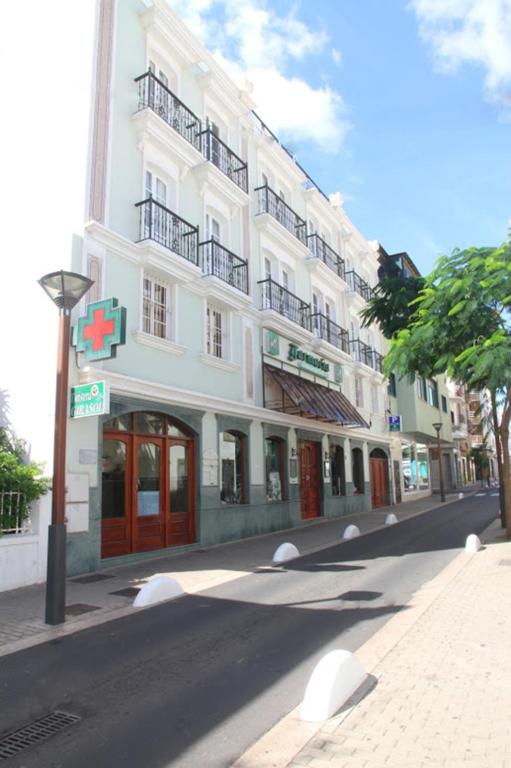 a large white building on the side of a street at Rooms & Suites Loft 2G Deluxe Edition Arrecife in Arrecife