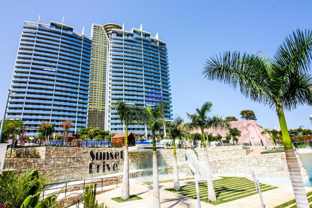 a resort with two tall buildings and palm trees at Sunset Drive by Albamar in Benidorm