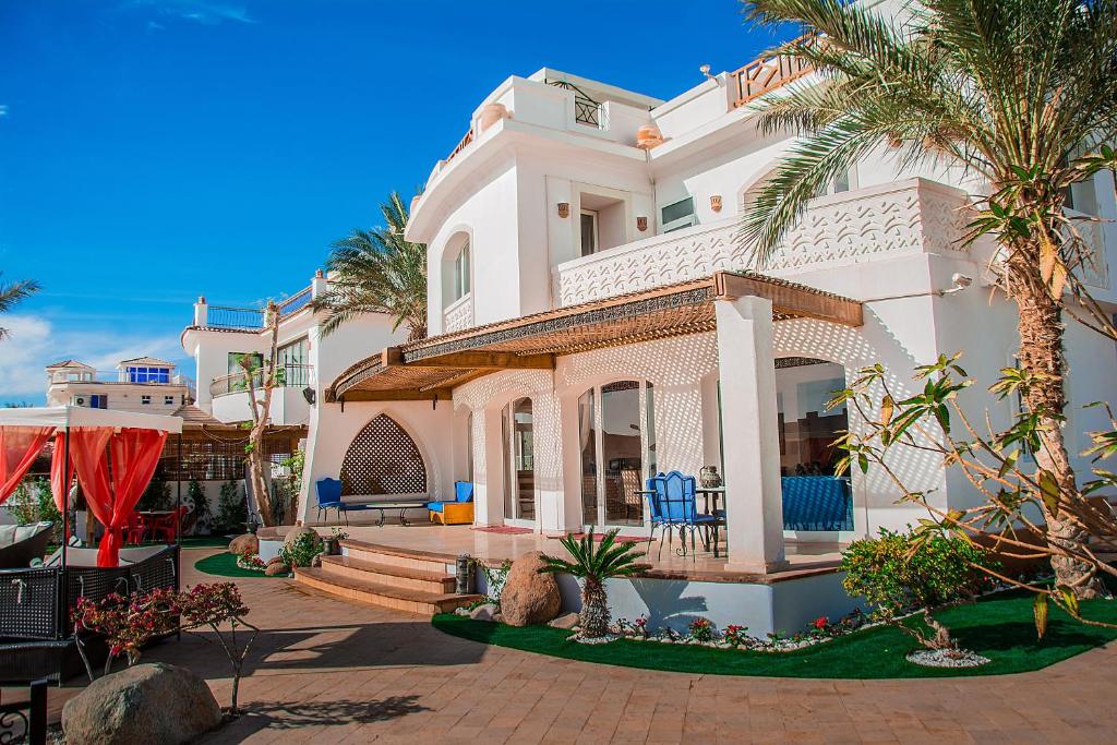 una gran casa blanca con palmeras delante en Jacaranda en Sharm El Sheikh