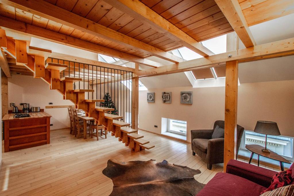a large living room with wooden floors and wooden stairs at Olives Ruterra Loft with Sauna in Prague
