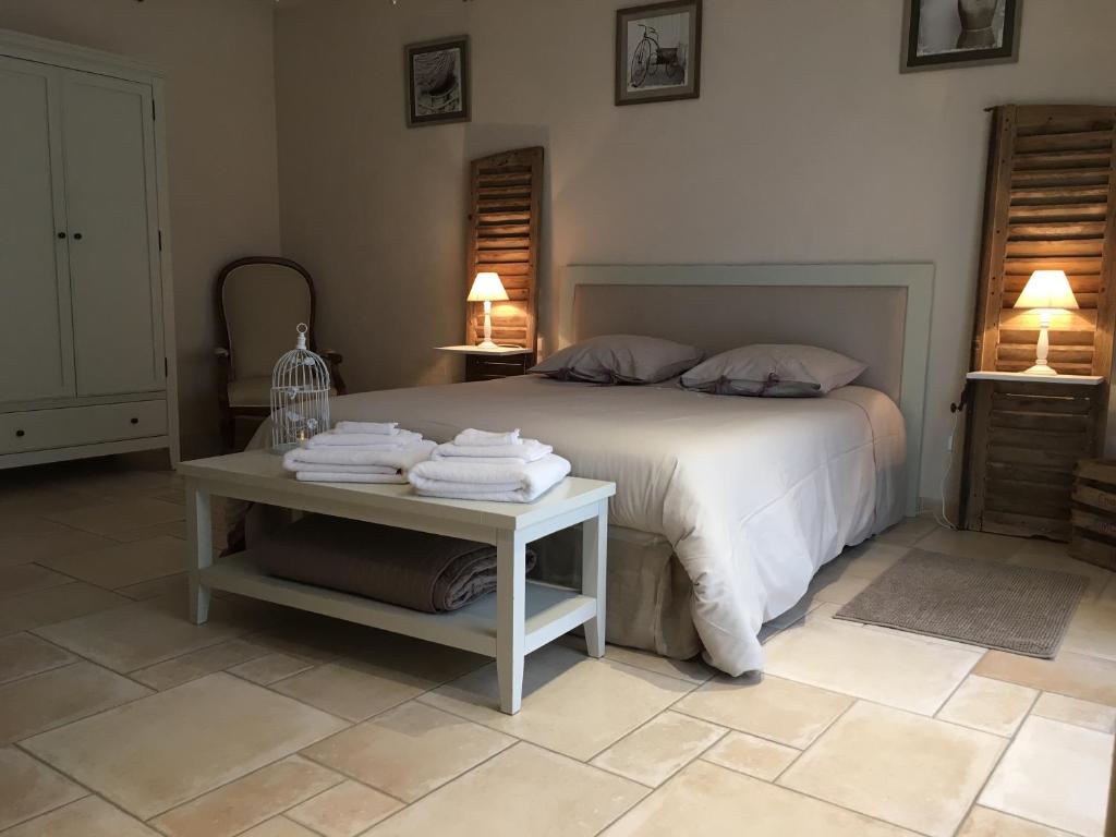 a bedroom with a bed and a table with towels at Le Gîte de Marie in Ludes