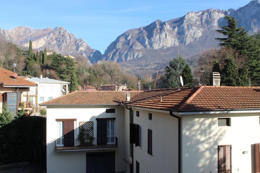 biały budynek z górą w tle w obiekcie Casa Orchidea w mieście Lecco
