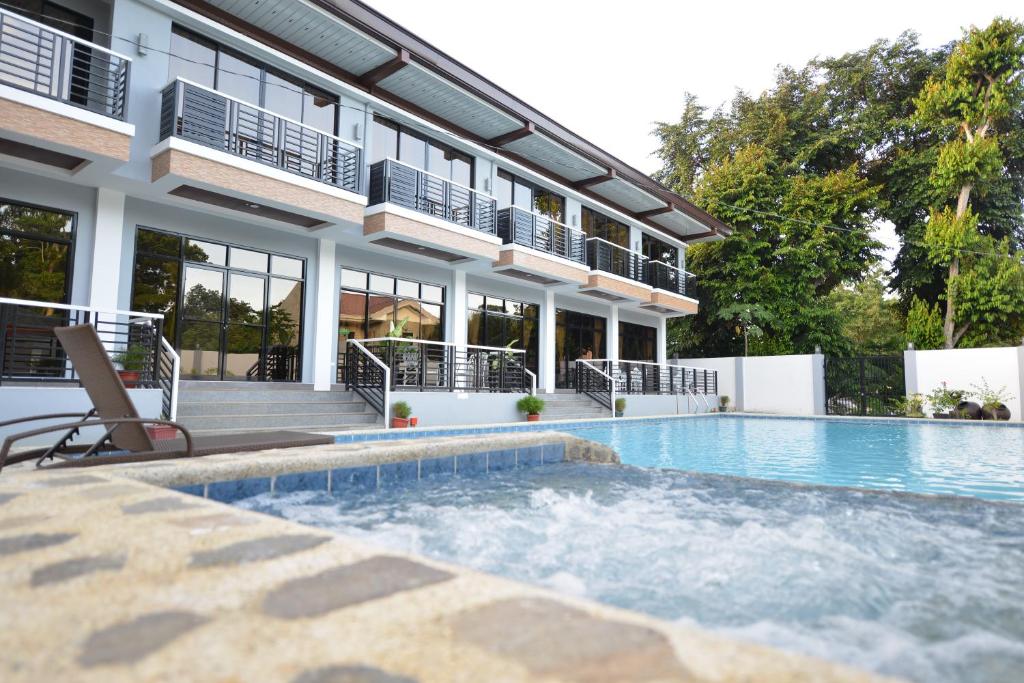 a house with a swimming pool in front of a building at Hotel Gabriella in Tagbilaran City