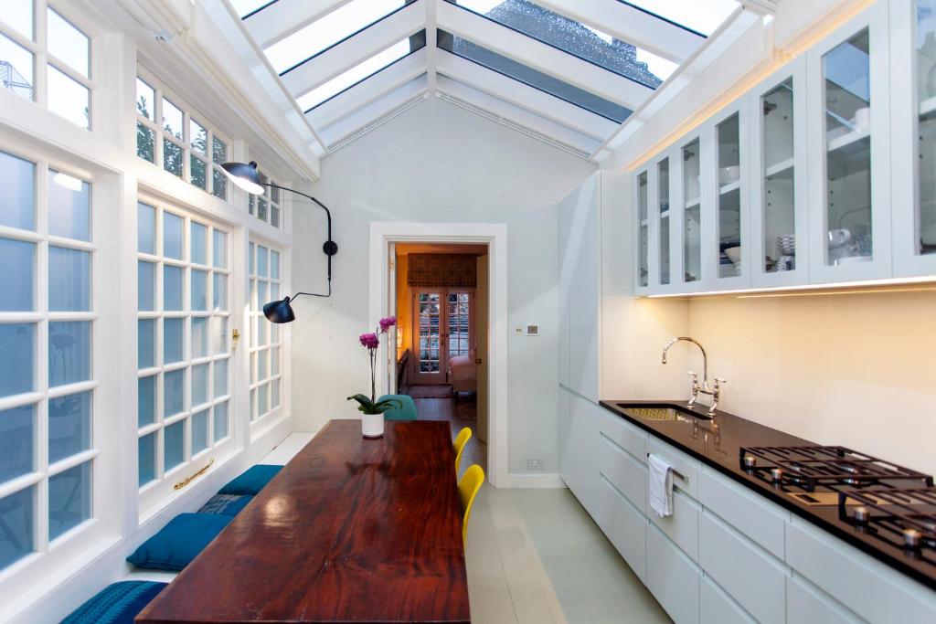 a kitchen with a skylight and a wooden table at Italianflat - Holland Park in London