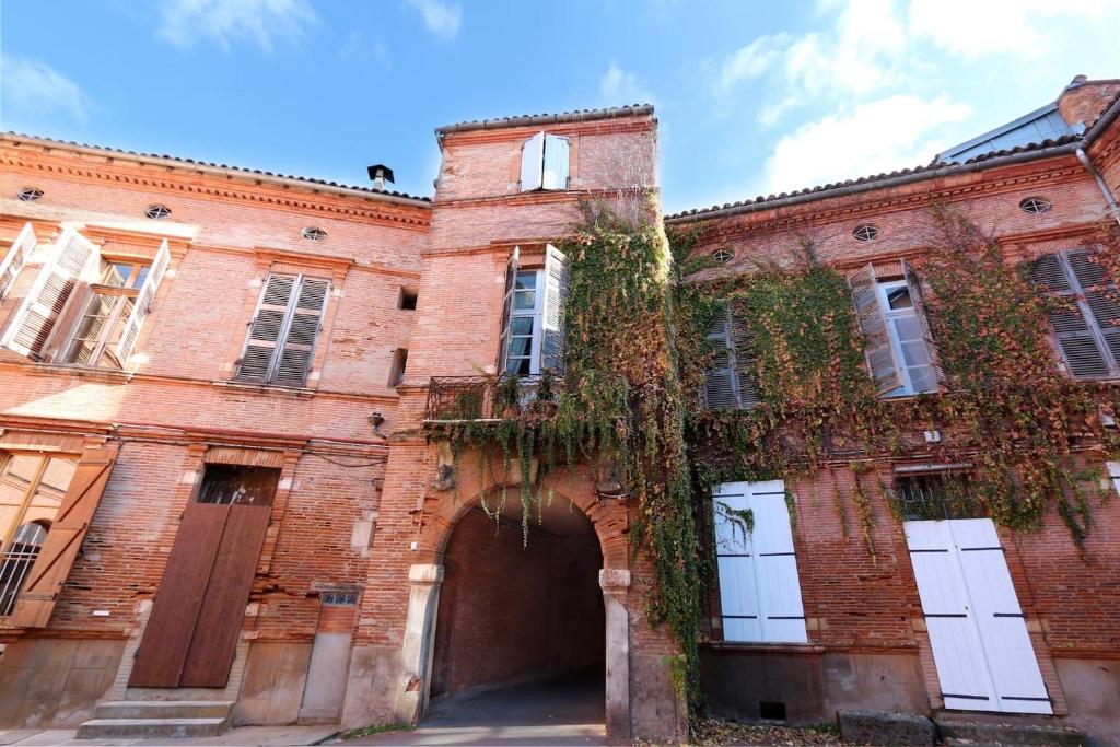 un ancien bâtiment en briques rouges avec une arche dans l'établissement Riverside Toulouse (Renaissance), à Toulouse