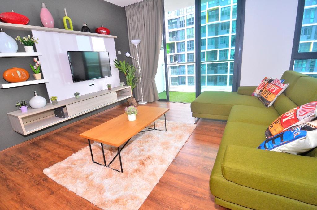 - un salon avec un canapé vert et une table dans l'établissement Kuching City New Luxury Vivacity Suite A3, à Kuching