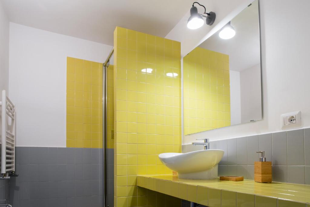 żółta łazienka z umywalką i lustrem w obiekcie Casa Magà w mieście Neapol