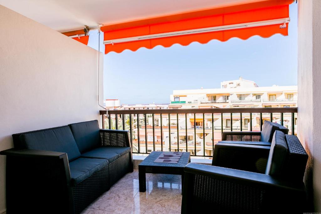 a living room with two couches and a balcony at Los Cristianos Guayero apartment in Los Cristianos