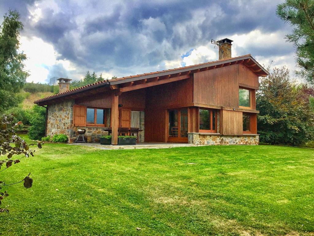 una casa con un césped verde delante de ella en Casa PereCampelles - Vall de Núria - Ripollès, en Campelles