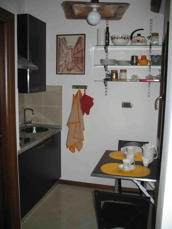 a small kitchen with a table and a sink at Piccolo appartamento a San Marco in Venice