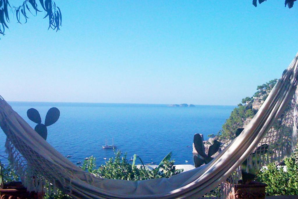 una persona seduta su un'amaca con vista sull'oceano di Casa Giardino a Positano