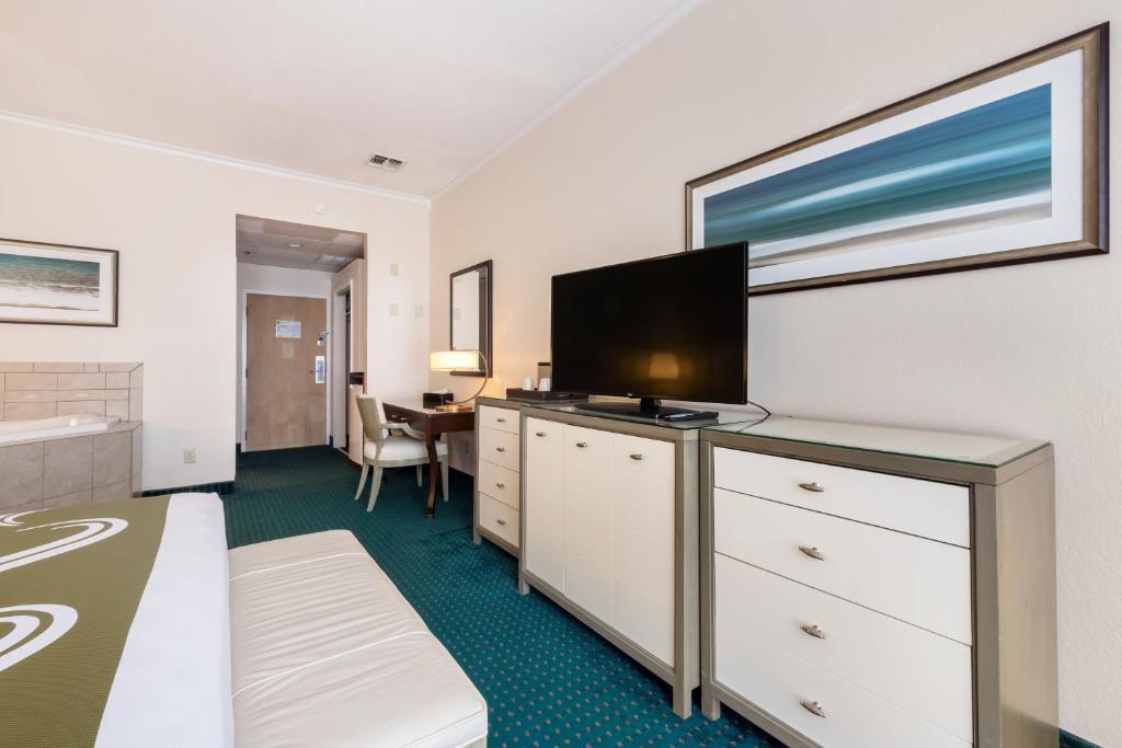 a hotel room with a bed and a flat screen tv at Quality Inn & Suites Conference Center in Winter Haven