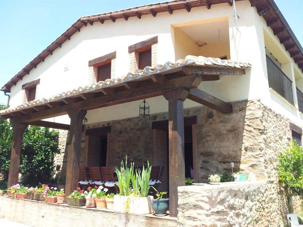 - une vue extérieure sur une maison avec une pergola en bois dans l'établissement Casa Rural Leonor con piscina privada, à Casar de Palomero