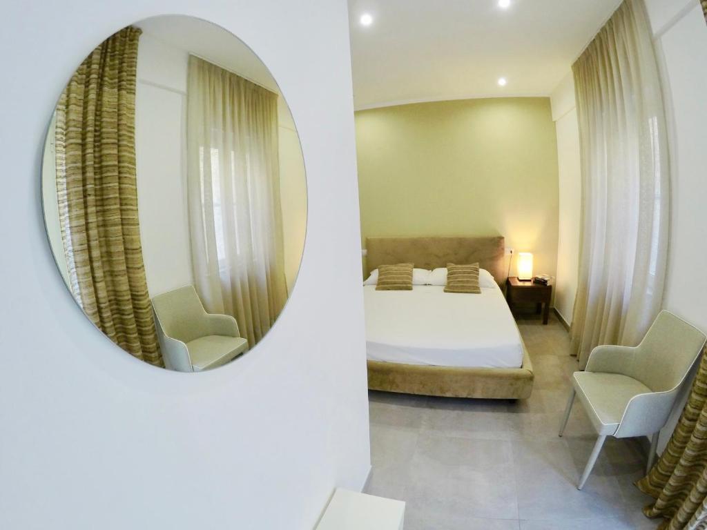1 dormitorio con cama y espejo en Petra Maris B&B, en Peschici