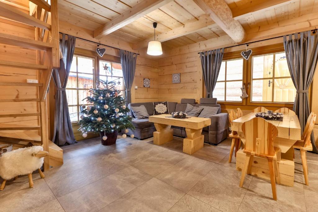a living room with a christmas tree in a cabin at Przytulny Domek I in Zakopane