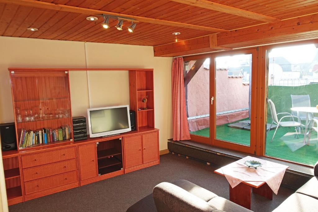 a living room with a couch and a tv at Ferienwohnung mit Wasserbett FW3 in Saalfeld