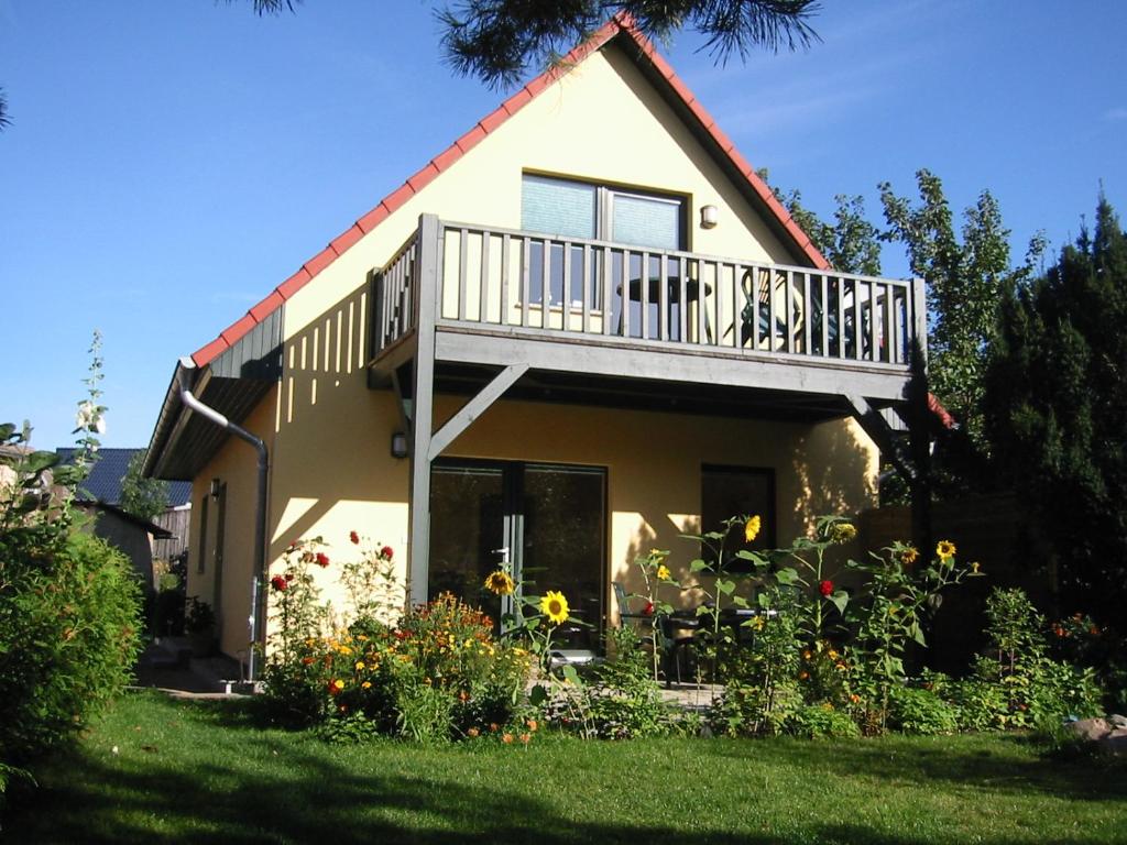 ein Haus mit Balkon darüber in der Unterkunft Ferienhaus Am Seeufer in Waren (Müritz)