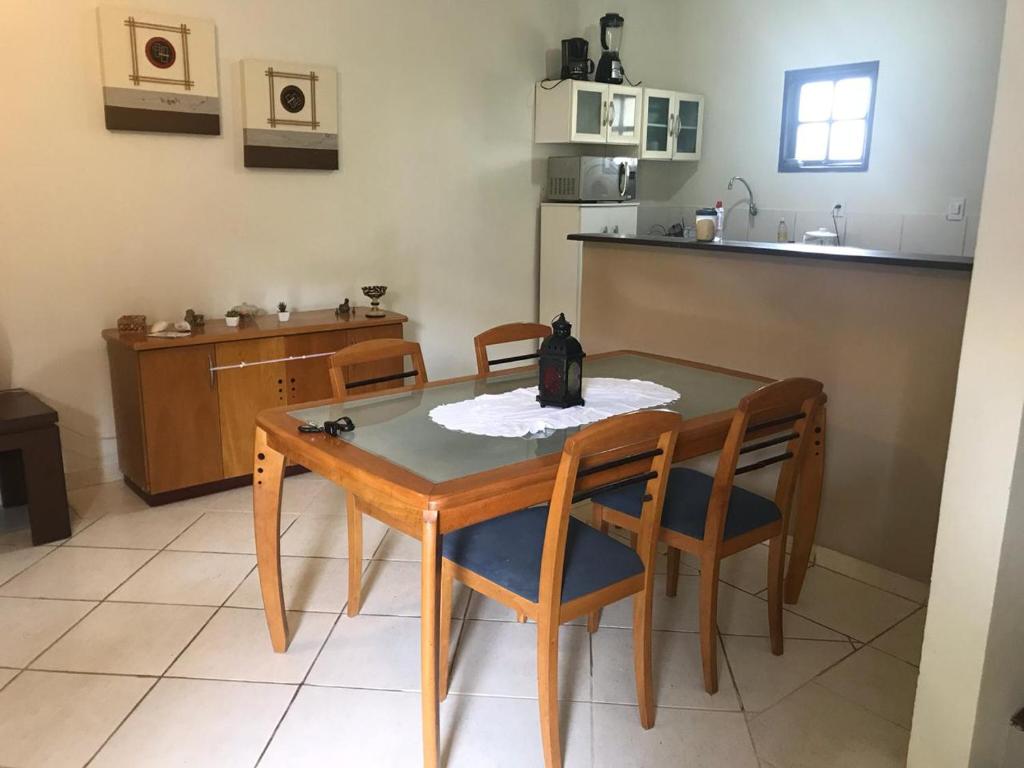 uma cozinha com mesa e cadeiras e uma cozinha com balcão em Casa Praia Rasa em Búzios