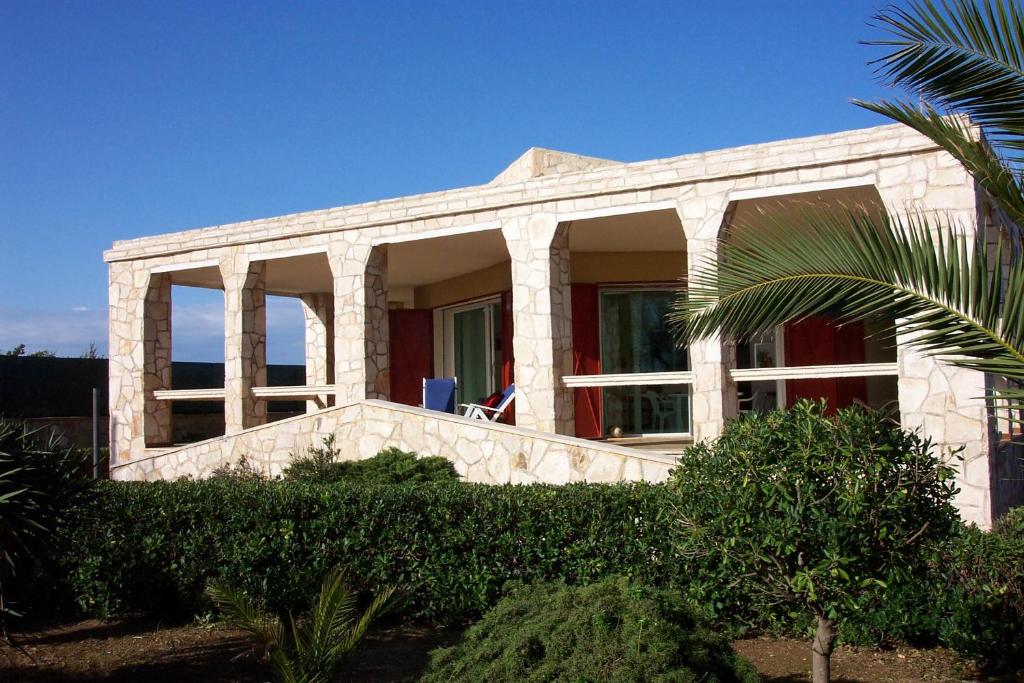 una casa blanca con una palmera delante de ella en Villa La Barca, en Maruggio