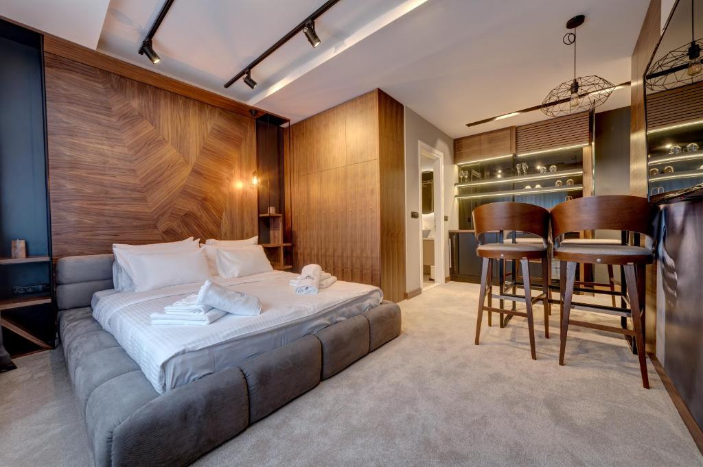 ein Hotelzimmer mit einem Bett und einer Bar in der Unterkunft Black Pearl Luxury Suites in Belgrad