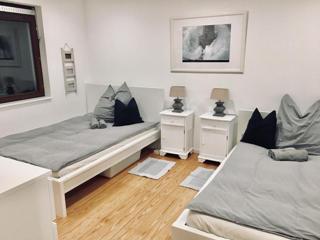 - une chambre avec 2 lits et 2 tables de chevet dans l'établissement 23 Fielweg, à Wewelsfleth