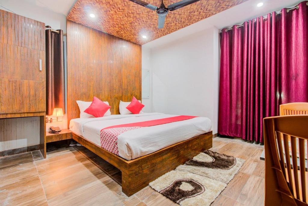 a bedroom with a bed and a red curtain at HOTEL RUDRAKSHA INN in Deoghar