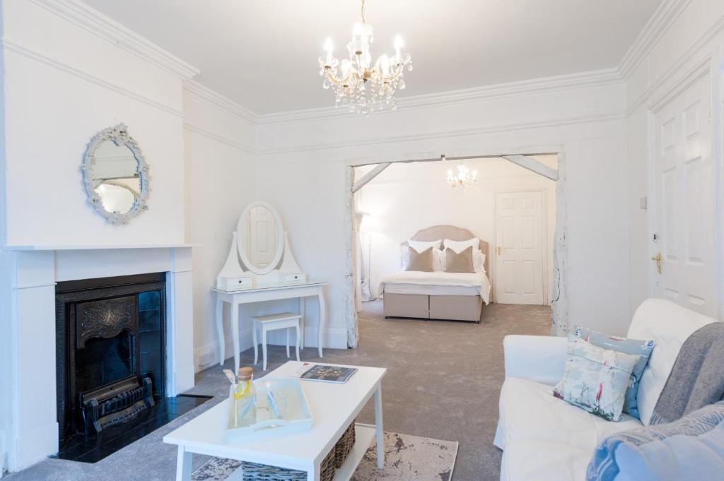 a living room with a fireplace and a bed at The Mariners Suite in West Mersea