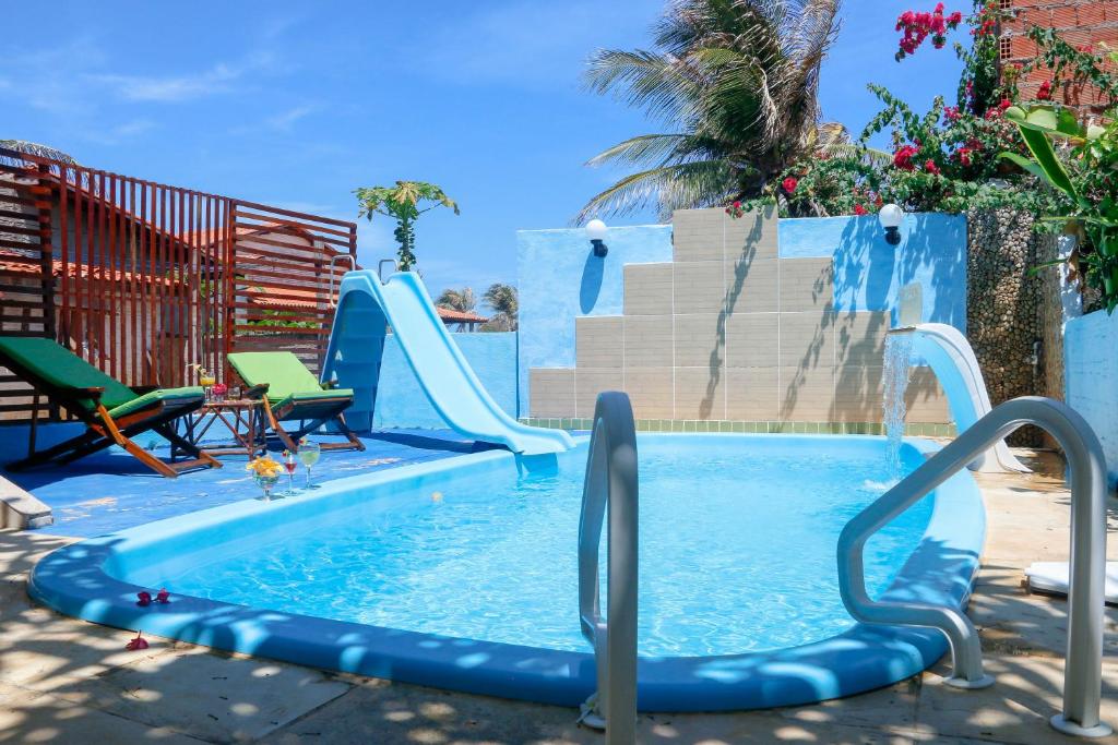 uma piscina com escorrega num quintal em Pousada Estrela do Oriente em Taíba