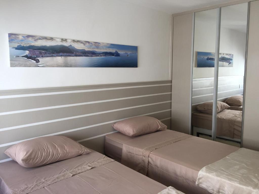 1 dormitorio con 2 camas y espejo en Praia de Copacabana Posto 6, en Río de Janeiro