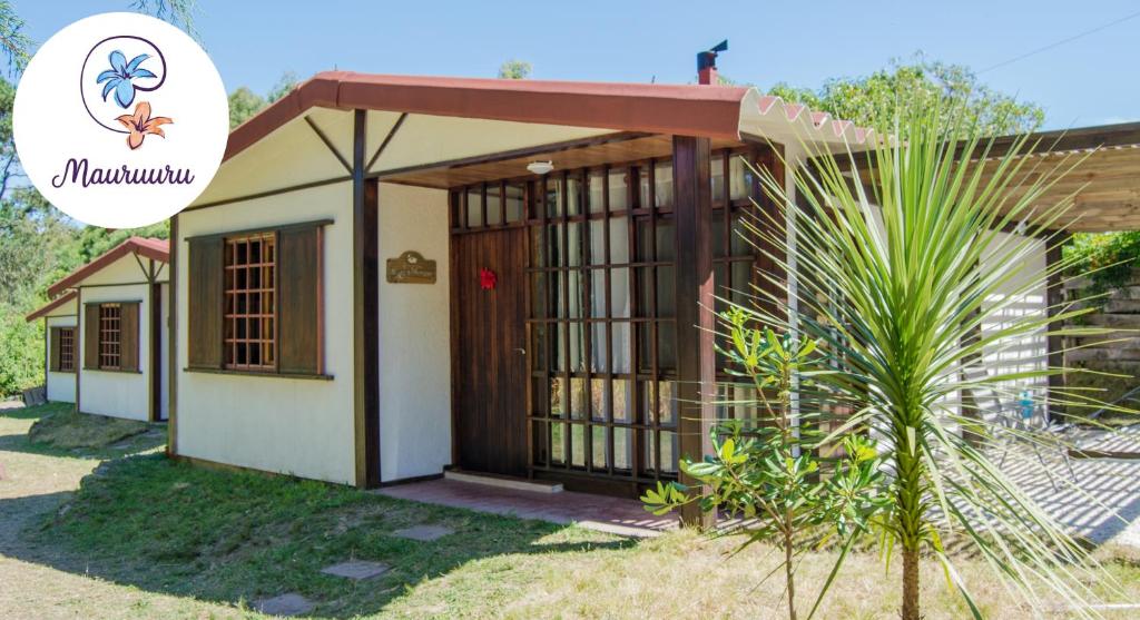 una casa con una puerta delante de ella en Mauruuru, en La Pedrera