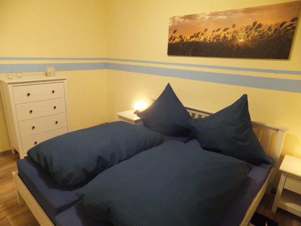 sypialnia z łóżkiem z niebieską pościelą i poduszkami w obiekcie Ferienhaus Langenmoor in der Natur! Abschalten in der Abgelegenheit! Haustiere willkommen! w mieście Armstorf
