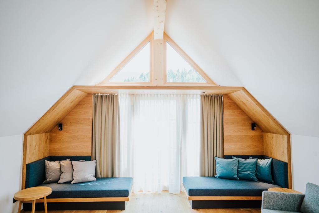 a room with two blue couches in front of a window at Der Kleine Bär in Hermagor