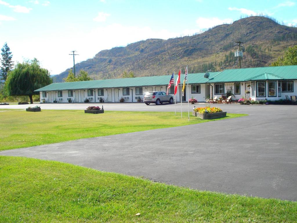 a building with two flags in front of it at Mountain Springs Motel & RV Park in Barrière