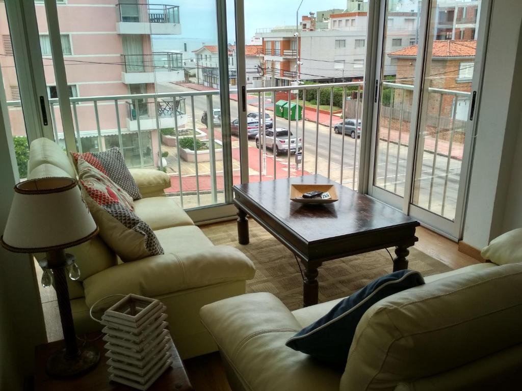 - un salon avec deux canapés, une table et une grande fenêtre dans l'établissement Club del Mar, à Punta del Este