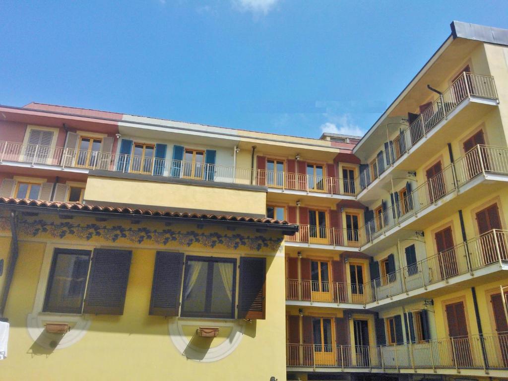 um edifício amarelo com varandas ao lado em Residence Corso Monferrato em Alessandria