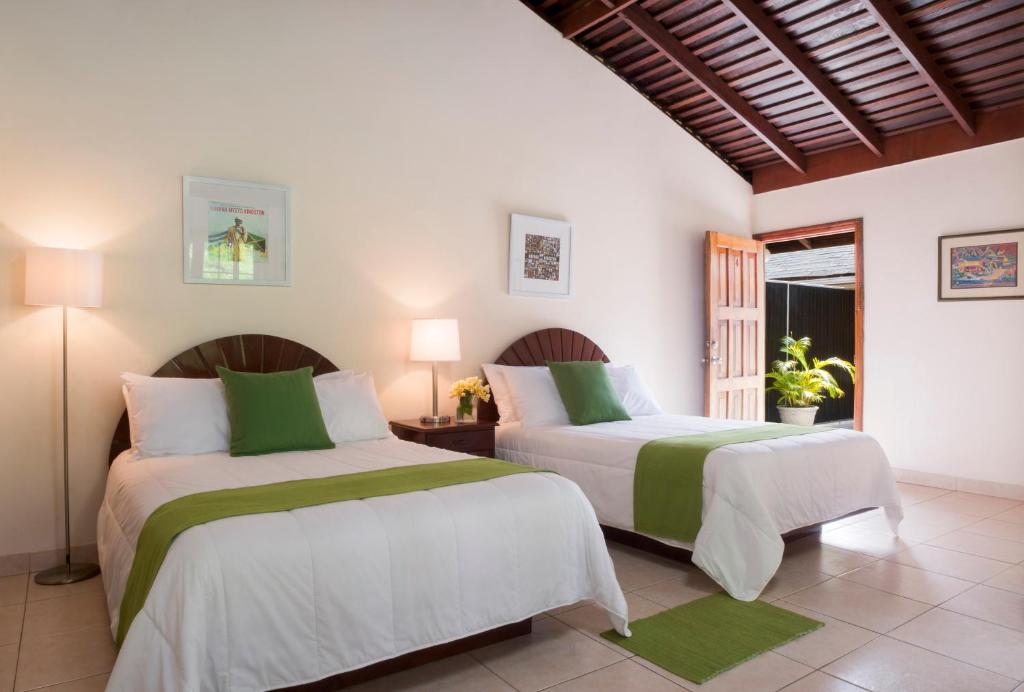 Un dormitorio con dos camas y una ventana. en White Sands Negril, en Negril