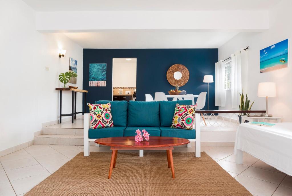 sala de estar con sofá azul y mesa en White Sands Negril, en Negril