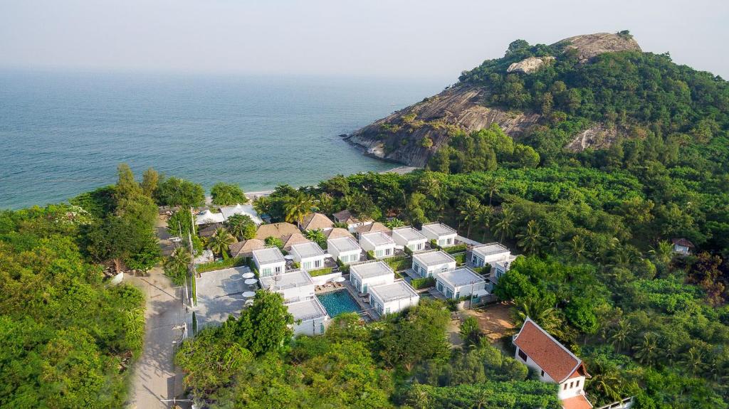 an aerial view of a house on a hill next to the ocean at T Villas Hua Hin in Khao Tao