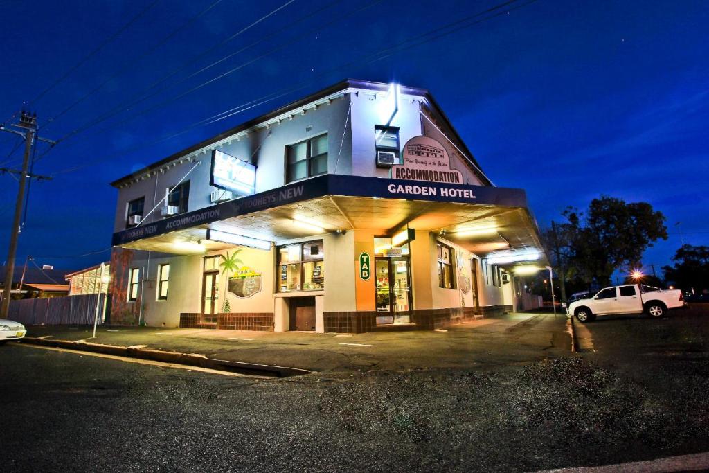 达博Garden Hotel的一辆白色汽车停在一栋建筑物前