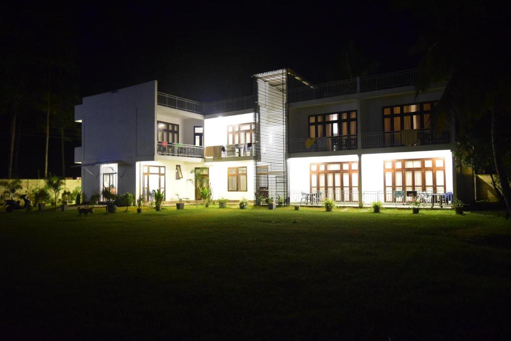 a large house at night with its lights on at Seacoast Sanctuary Beach Hotel in Hiriketiya