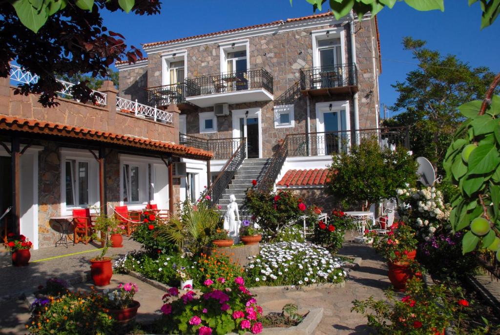 ミティムナにあるMolyvos Queen Apartmentsの花の前の建物