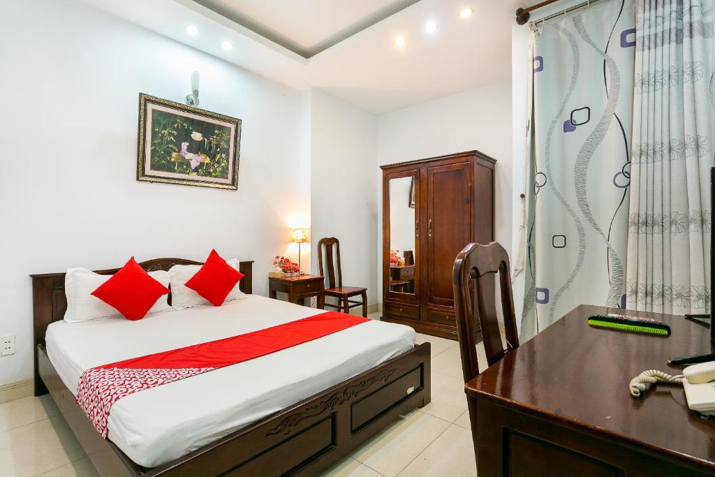 1 dormitorio con cama, escritorio y ducha en Tuan Long Hotel en Ho Chi Minh