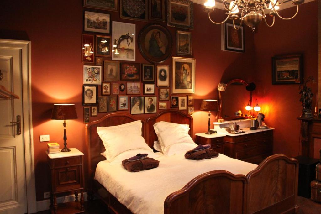 a bedroom with a bed and a wall of pictures at B&B De Lachende Engel in Mechelen